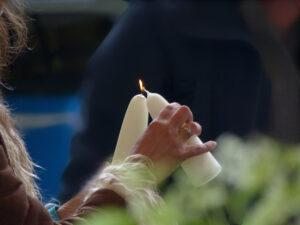 De gasten bij een handfasting ceremonie delen het licht met elkaar door het aansteken van één speciale kaars voor elk, aan elkaars vlam.